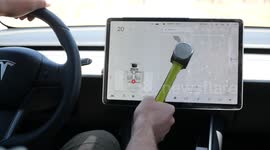 Man smashes Tesla Model 3 screen with sledge hammer while driving