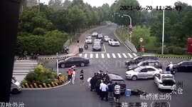 Pedestrians work together to rescue biker trapped underneath car on Chinese road