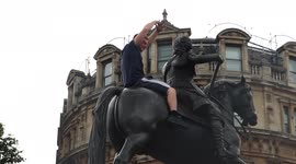Protester Almost Slips Off Statue As Attempting To Get Down. At The London Anti Lockdown Protest