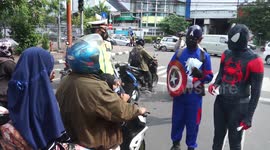 Police in Avengers costumes distribute masks on the streets in Makassar
