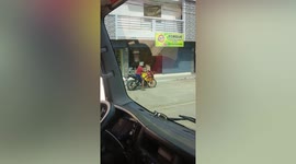 Man wears DIY helmet while riding motorcycle to market