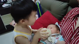 Sweet moment of 3-year-old brother milk feeding his newborn sister