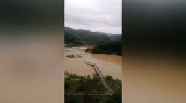Steel bridge washed away by flooded river in southern China