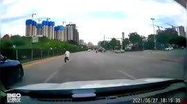 Car narrowly misses girl running across busy road in southwestern China