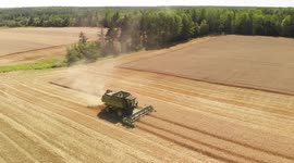 John Deer Combine harvesting wheat shot on drone. Many angles including grain truck