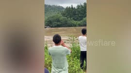 Steel bridge washed away as flash floods hit China