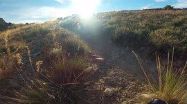 First-person view of trail runner climbing up a mountain at sunrise