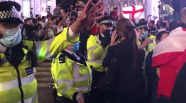Police disperse England fans celebrating and throwing bottles in Piccadilly Circus, London