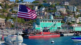 Hundreds of boats in Avalon Harbor on Santa Catalina Island off the coast of Southern California - sound their horns at 5pm everyday to honor first responders during the COVID-19 pandemic. It is a beautiful day with hundreds of waving American flags again