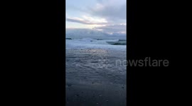 People walk on the sea after a daytime storm in Sochi, Russia