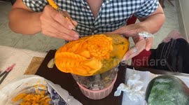 Skill and precision on show as man carves intricate flower into papaya