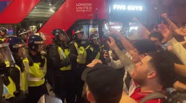 Football fans confront riot police in central London after chaotic victory celebrations