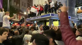 England football fans climb on top of Leicester Square Station as they celebrate England’s win over Denmark in the Euro 2020 semi-final