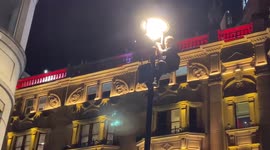English supporters climb light poles in London following country's Euro 2020 win over Denmark