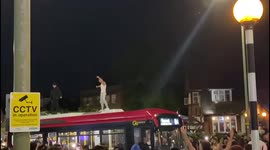 England fans walks along top of London bus after win over Denmark