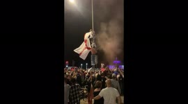 England fans in Brighton climb lamppost and wave massive St George flag after semi-final win