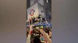 England fans climb onto Leicester Square station while singing 'Sweet Caroline'