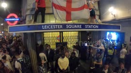 England fans hoist St George flag on top of Leicester Square station