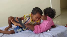 Fighting for the phone with his brother. Brother is controlling the anger