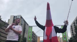Lairy England fans, one with a traffic cone on his head, and another who catches a flying beer bottle, party outside Wembley Stadium ahead of Euro 2020 final