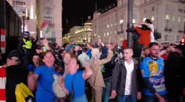 Italy fans celebrate in Piccadilly Circus while riot Police separate England fans