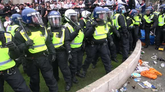 The moment an England fan gets glass bottle to the head as football fans clash with police at Trafalgar Square in London during Euro 2020 final