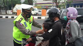 Police put masks on motorbike riders in Indonesia to prevent Covid-19