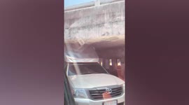 Truck gets stuck under low-lying bridge after driver misjudges depth