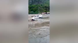 Chinese villager runs into rapid floodwater to rescue tourist