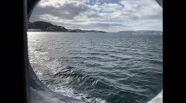 View of Choppy Ocean Waves Through a Porthole on Ferry Boat Ride