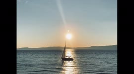 Serene Sailboat Crosses the Sunset Horizon in Trondheim Norway
