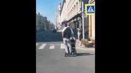 Man rides segway as he pushes child stroller along road in Russia