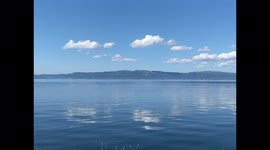 Placid Serene Blue Water on Bright Sunny Day Few Clouds in the Sky