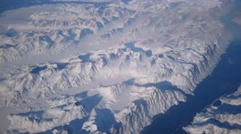 Flying over Greenland at 35,00 feet snow against bright blue sky