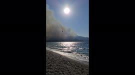 Fire brigade helicopter putting out island fire in samos Greece