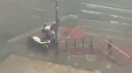 Chinese mother protects daughter in powerful winds after falling down from scooter