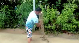 Locals catch fish on flooded road after heavy rain in Thailand