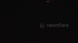 Airplanes fly across a night sky with dramatic flashes of lightning.