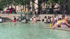 UK heatwave: People dip their feet in the fountains at London’s Trafalgar Square