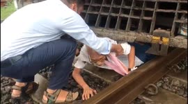 Terrifying moment elderly man is rescued from under a train in western India