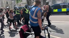 Freedom Day: Young woman is escorted by several police officers during anti-lockdown protest