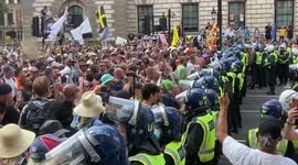 Police in riot gear hold back huge throng of protesters trying to reach Whitehall from Parliament Square