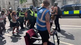 17. Police arrest a young woman at an anti-lockdown protest in London