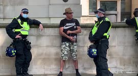 A man is arrested and held in handcuffs by police at London anti-lockdown rally