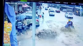 Motorcyclists swept down road by rapid floodwater in southwest China