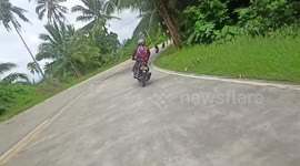 Motorcycle rider flings himself onto road side to avoid oncoming truck