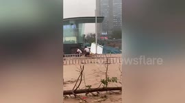 Pedestrians rescue woman being swept away by rapid floods in central China