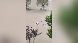 Locals rush to prevent woman from being swept away by floodwater in China