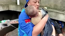 Baby trapped amongst rubble of collapsed house is rescued in flood-stricken central China