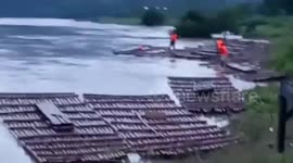 Desperate residents use wood to cross river during typhoon In-fa in the Philippines